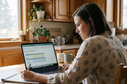Femme concentrée calculant un prêt immobilier à la maison